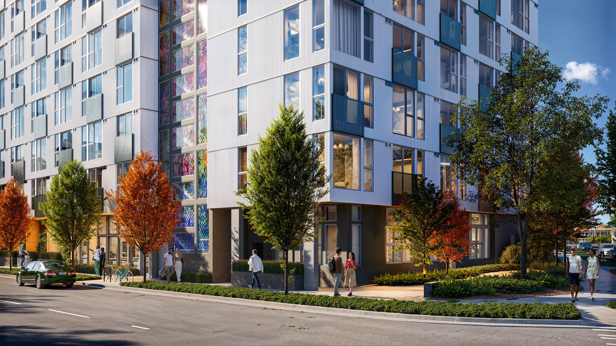 A modern building with a lot of windows and trees in front.